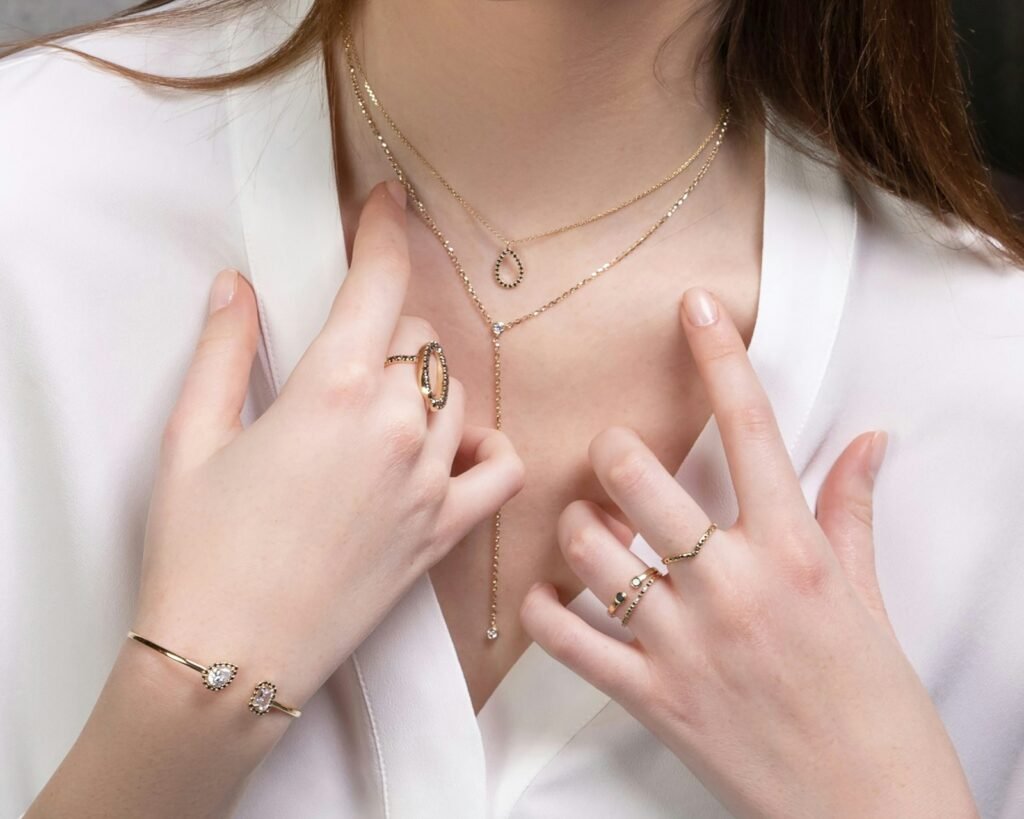 Mujer con collares delicados, anillos y pulsera dorada